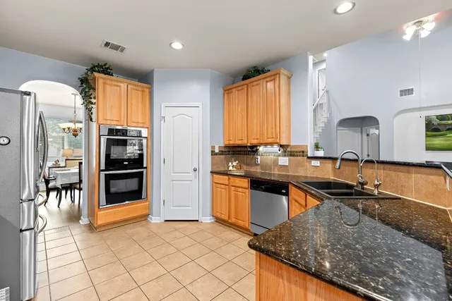 a kitchen with stainless steel appliances granite countertop a stove sink and cabinets