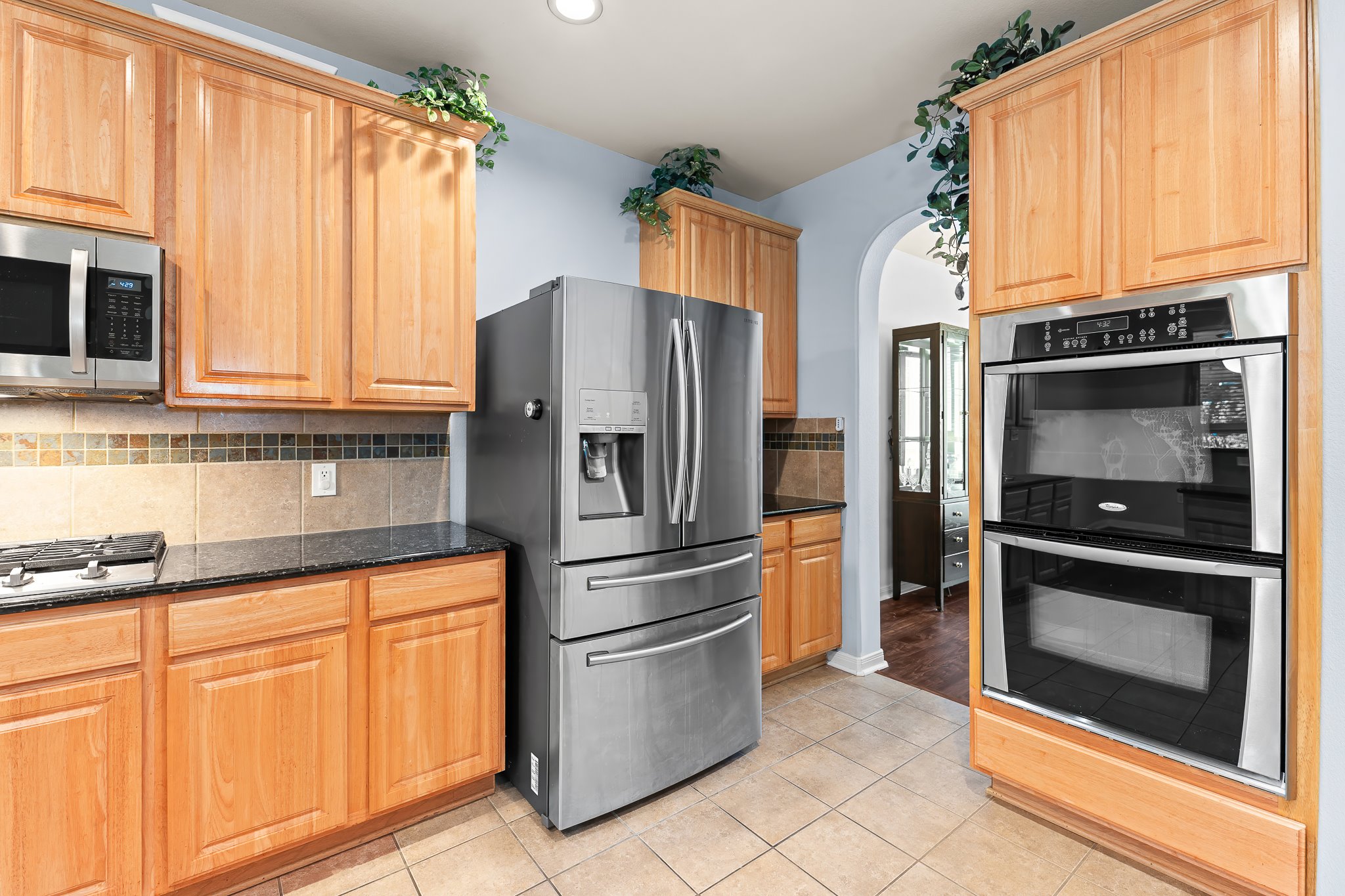 1211 Laurel Oak Trail Pflugerville, TX 78660 - Photo 17 of 40 a kitchen with stainless steel appliances granite countertop a refrigerator microwave and sink