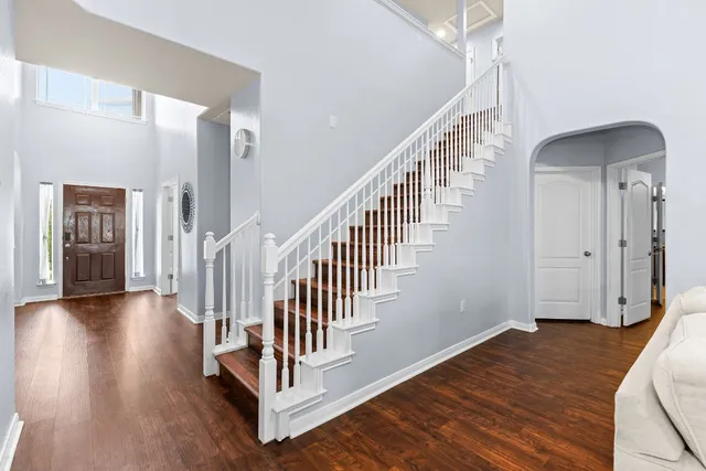 a view of a hallway with wooden floor and staircase