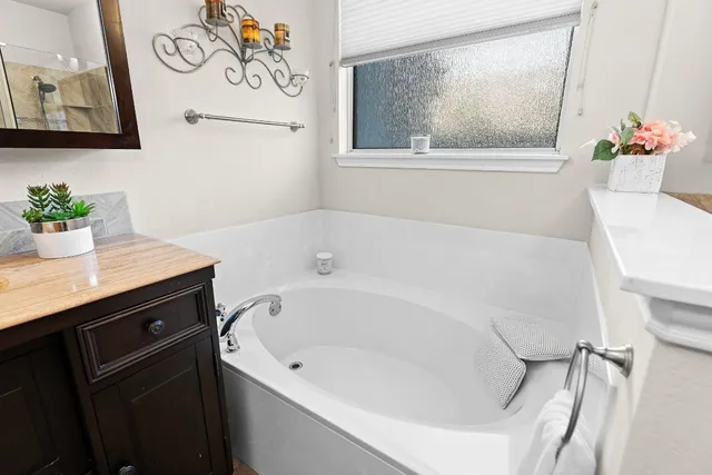 a bathroom with a bathtub sink and mirror