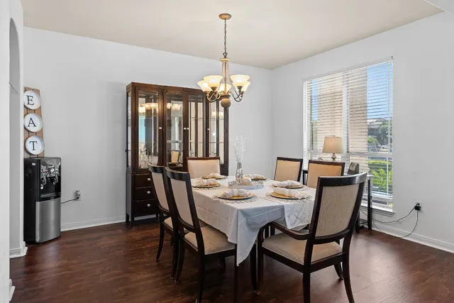 a dining room with furniture a chandelier and wooden floor
