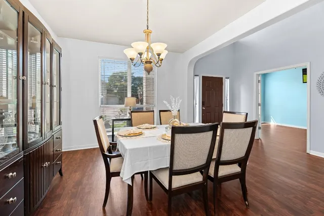 a view of a dining room with furniture wooden floor and chandelier