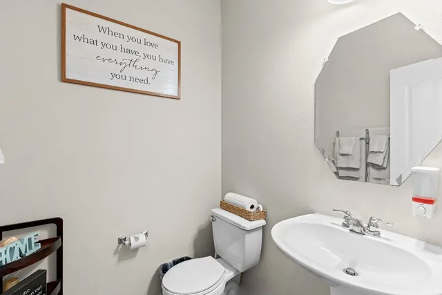 a bathroom with a toilet sink and mirror
