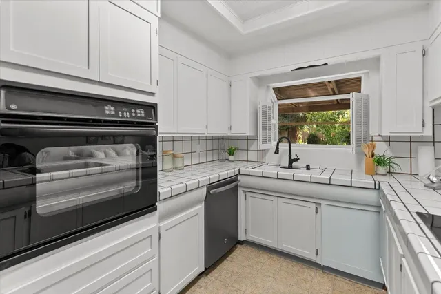 a living room with furniture a flat screen tv and a window