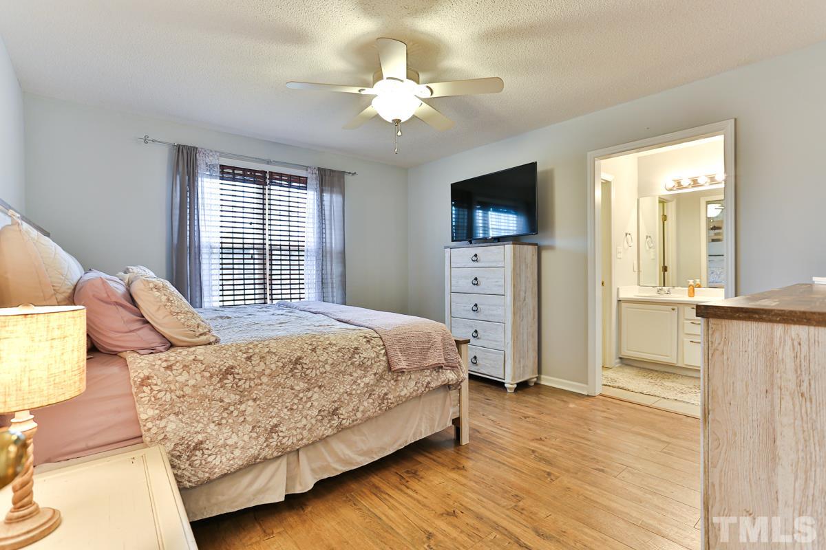 243 Rosa Circle Willow Spring, NC 27592 - Photo 14 of 28 a bedroom with a bed a window and a flat screen tv