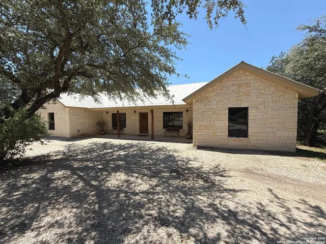 a view of a house with a yard and large tree