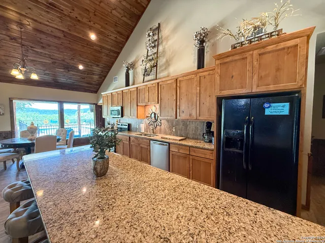 a kitchen with stainless steel appliances kitchen island granite countertop a refrigerator and microwave