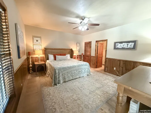 a bedroom with a large bed and a chandelier