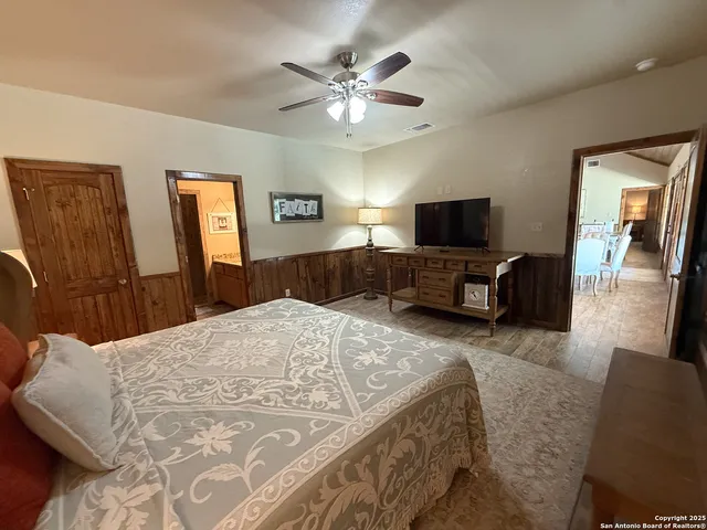 a spacious bedroom with a bed and a flat screen tv