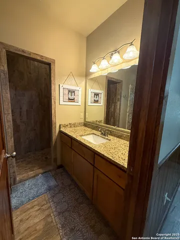 a bathroom with a granite countertop sink and a mirror