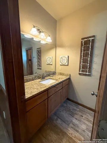 a bathroom with a granite countertop sink and a mirror