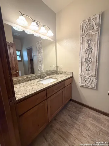 a bathroom with a granite countertop sink a mirror a vanity and shower