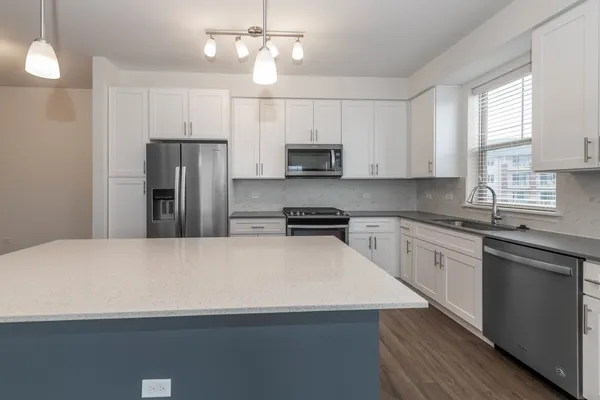 a kitchen with stainless steel appliances a refrigerator sink and microwave