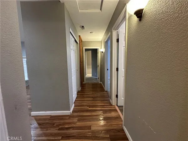 a view of a room with wooden floor and a bathroom