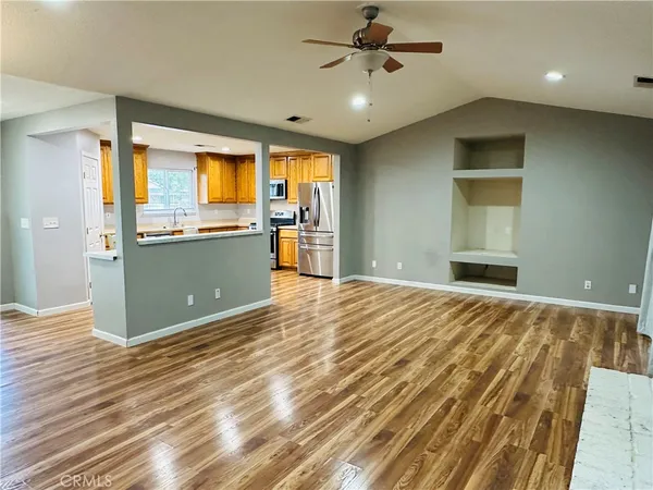 a view of an empty room with a fireplace and a window