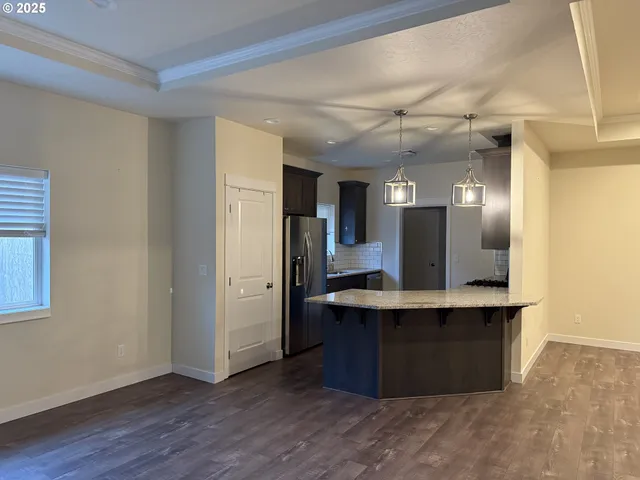 a view with kitchen island a sink wooden floor and a refrigerator