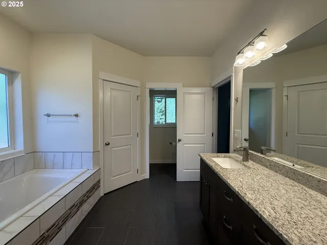a bathroom with a granite countertop sink and a large mirror