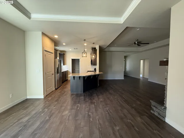 a view of a big room with wooden floor and a kitchen