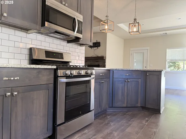 a kitchen with stainless steel appliances granite countertop a stove and a microwave