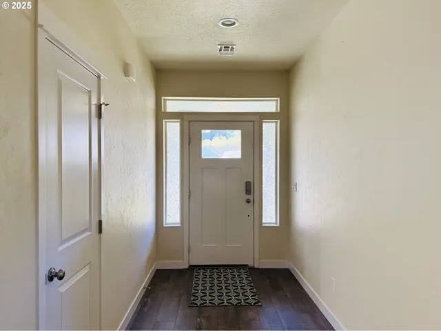a view of a hallway with wooden floor and a bathroom