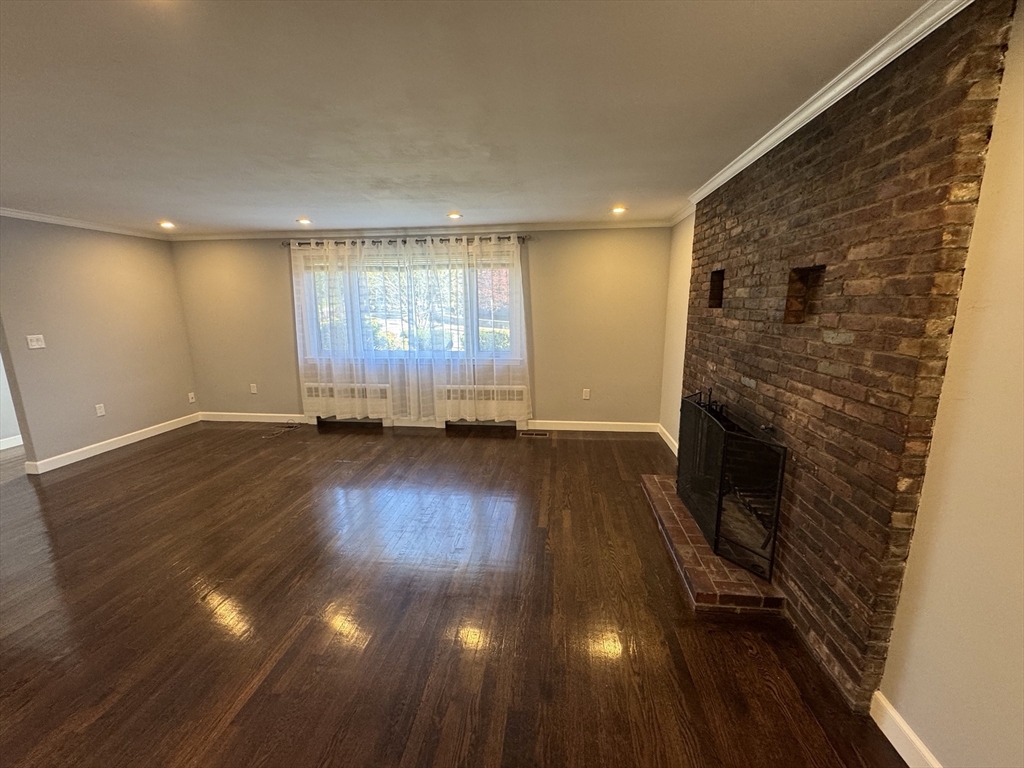 an empty room with wooden floor and fireplace