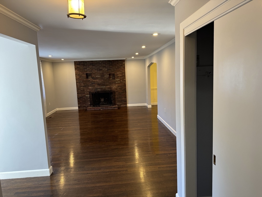 793 Dedham Street Newton, MA 02459 - Photo 13 of 26 a view of a hallway with wooden floor and a fireplace