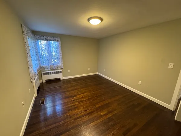 an empty room with wooden floor and a window