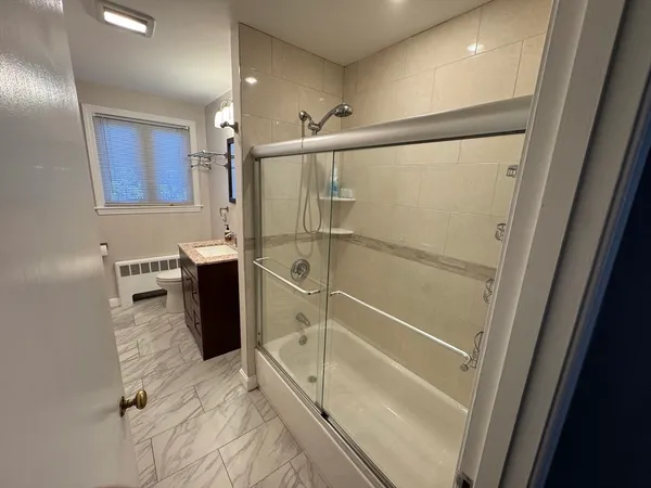 a bathroom with a toilet a sink a shower and mirror