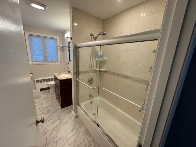 a bathroom with a toilet a sink a shower and mirror