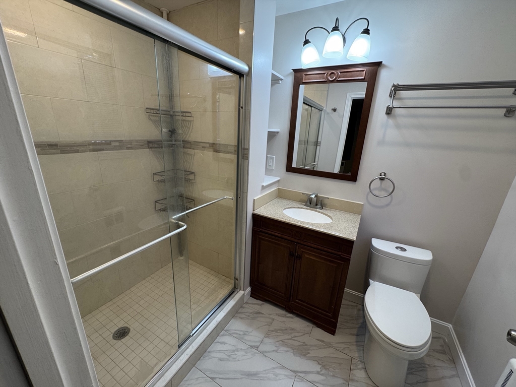 793 Dedham Street Newton, MA 02459 - Photo 18 of 26 a bathroom with a toilet a sink a shower and mirror