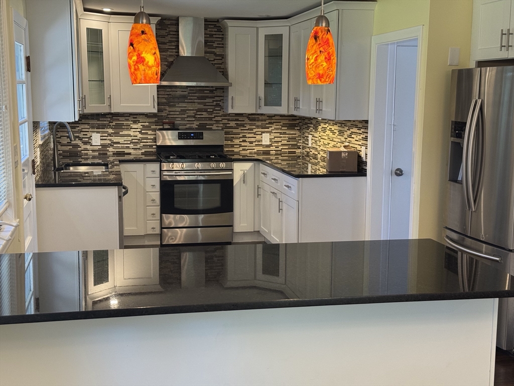 793 Dedham Street Newton, MA 02459 - Photo 20 of 26 a kitchen with stainless steel appliances granite countertop a stove and a refrigerator