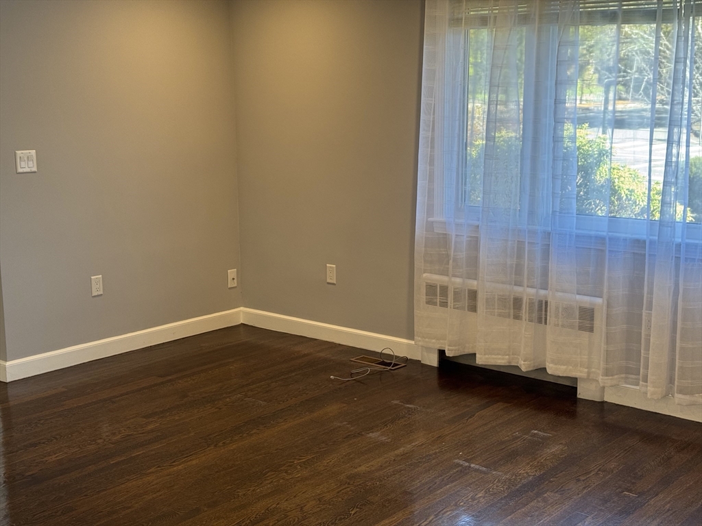 793 Dedham Street Newton, MA 02459 - Photo 2 of 26 an empty room with wooden floor and windows
