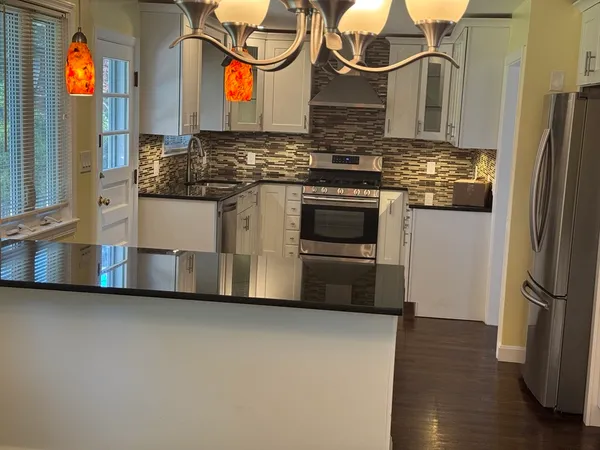 a view of a living room a kitchen and a wooden floor