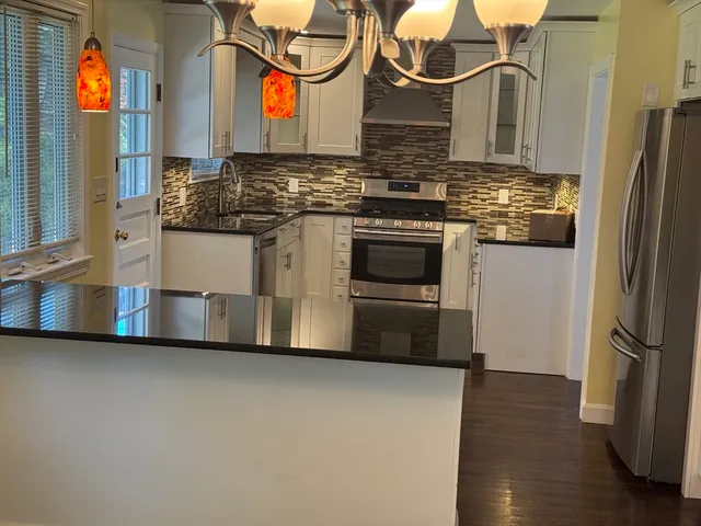 a view of a living room a kitchen and a wooden floor