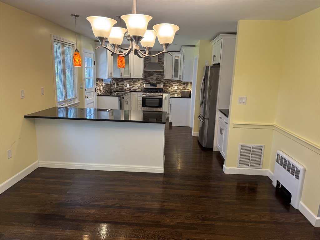 793 Dedham Street Newton, MA 02459 - Photo 23 of 26 a kitchen with stainless steel appliances granite countertop a refrigerator a stove and a wooden floors