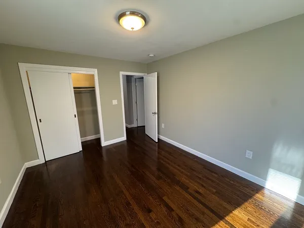 an empty room with wooden floor and closet