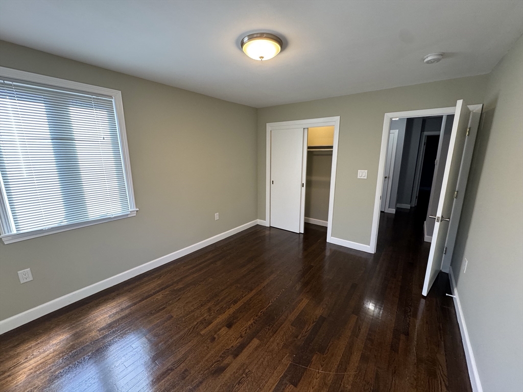 793 Dedham Street Newton, MA 02459 - Photo 5 of 26 an empty room with wooden floor and windows
