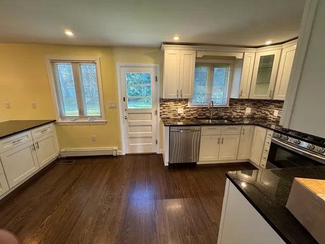 a kitchen with stainless steel appliances granite countertop a stove a sink and a refrigerator