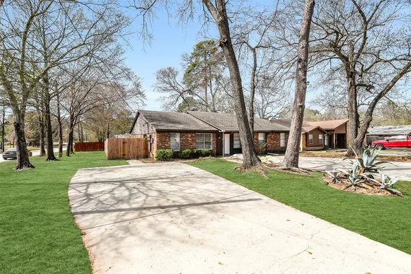 a front view of a house with a garden and trees