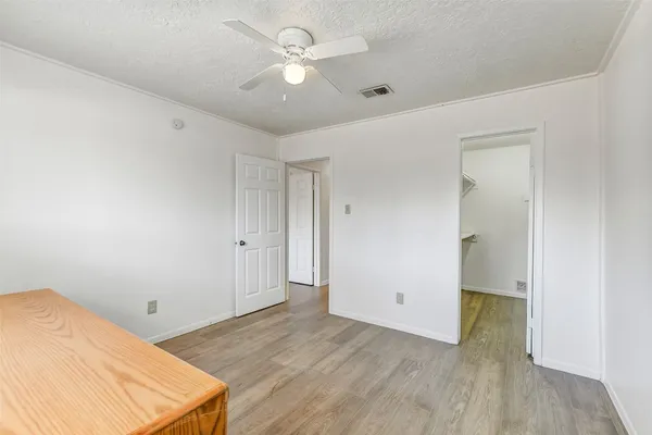 a view of a room with wooden floor and ceiling fan