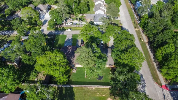 an aerial view of residential house with outdoor space and trees all around