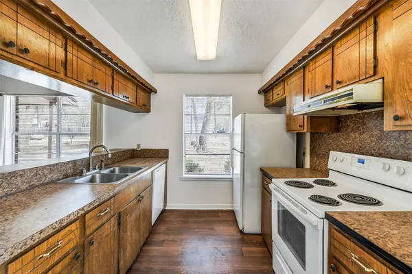 a kitchen with granite countertop a sink stove and refrigerator