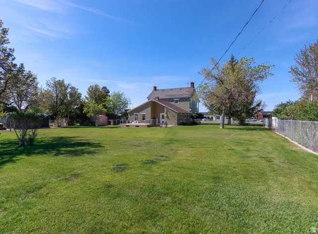 155 West Center Street Fillmore, UT 84631 - Photo 73 of 86 Expansive green lawn with mature trees and a chain-link fence