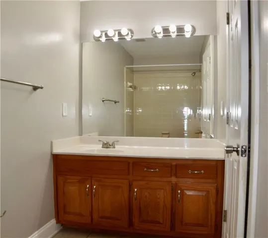 a bathroom with a granite countertop sink a mirror and a vanity