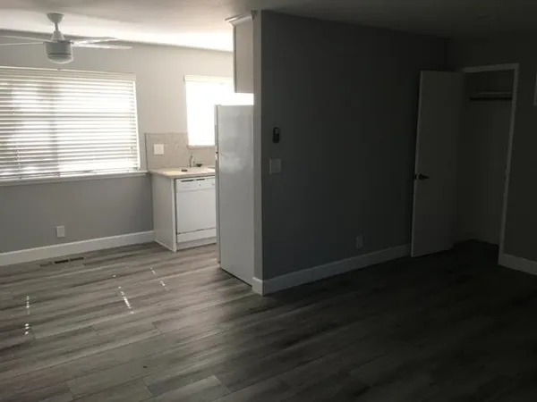 a view of a kitchen with wooden floor and a window
