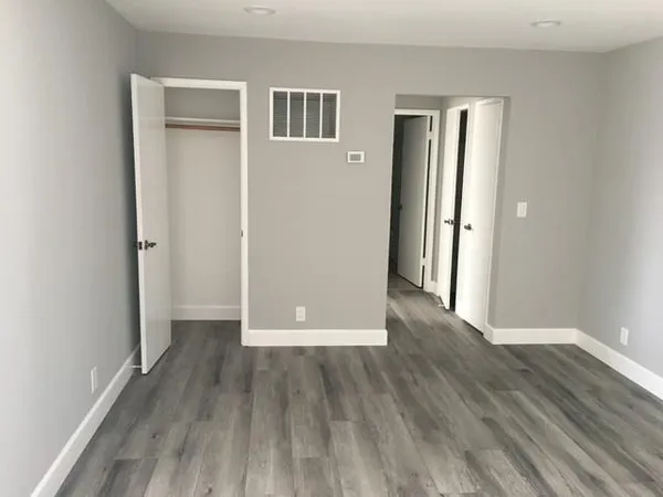 an empty room with wooden floor and a window