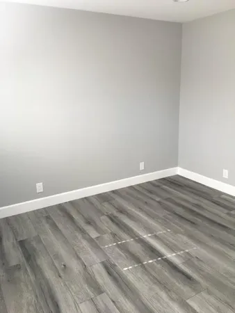 a view of an empty room with wooden floor