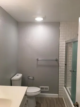 a bathroom with a toilet and a shower