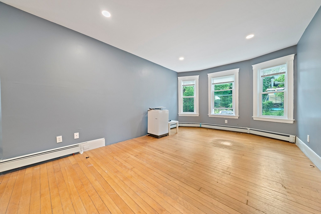 10 Trowbridge Road Worcester, MA 01609 - Photo 12 of 38 a view of an empty room with a window and wooden floor