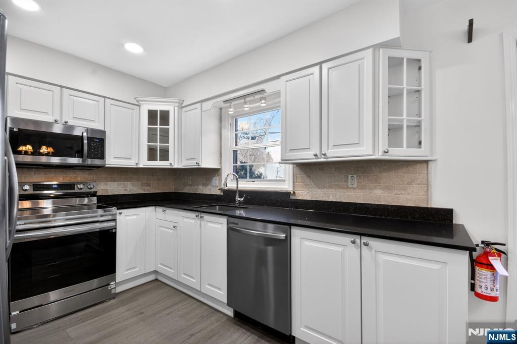 260 Prospect Street, Unit 12 Westfield, NJ 07090 - Photo 8 of 14 a kitchen with stainless steel appliances granite countertop a stove and a microwave
